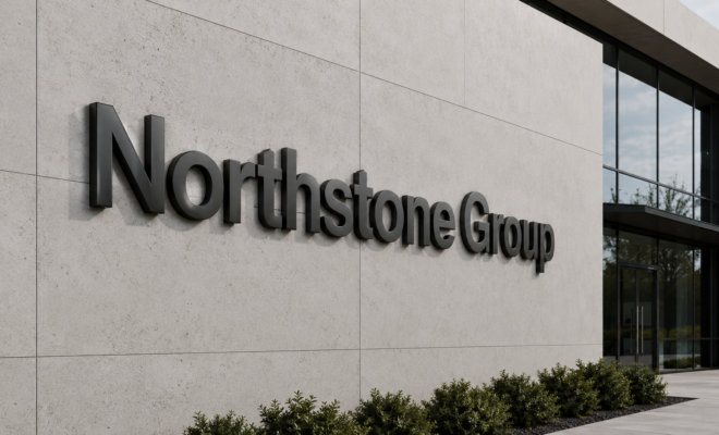 Schwarze 3D-Buchstaben "Northstone Group" an heller Betonfassade neben großen Glasfenstern, niedrige Büsche am Gebäudefuß.