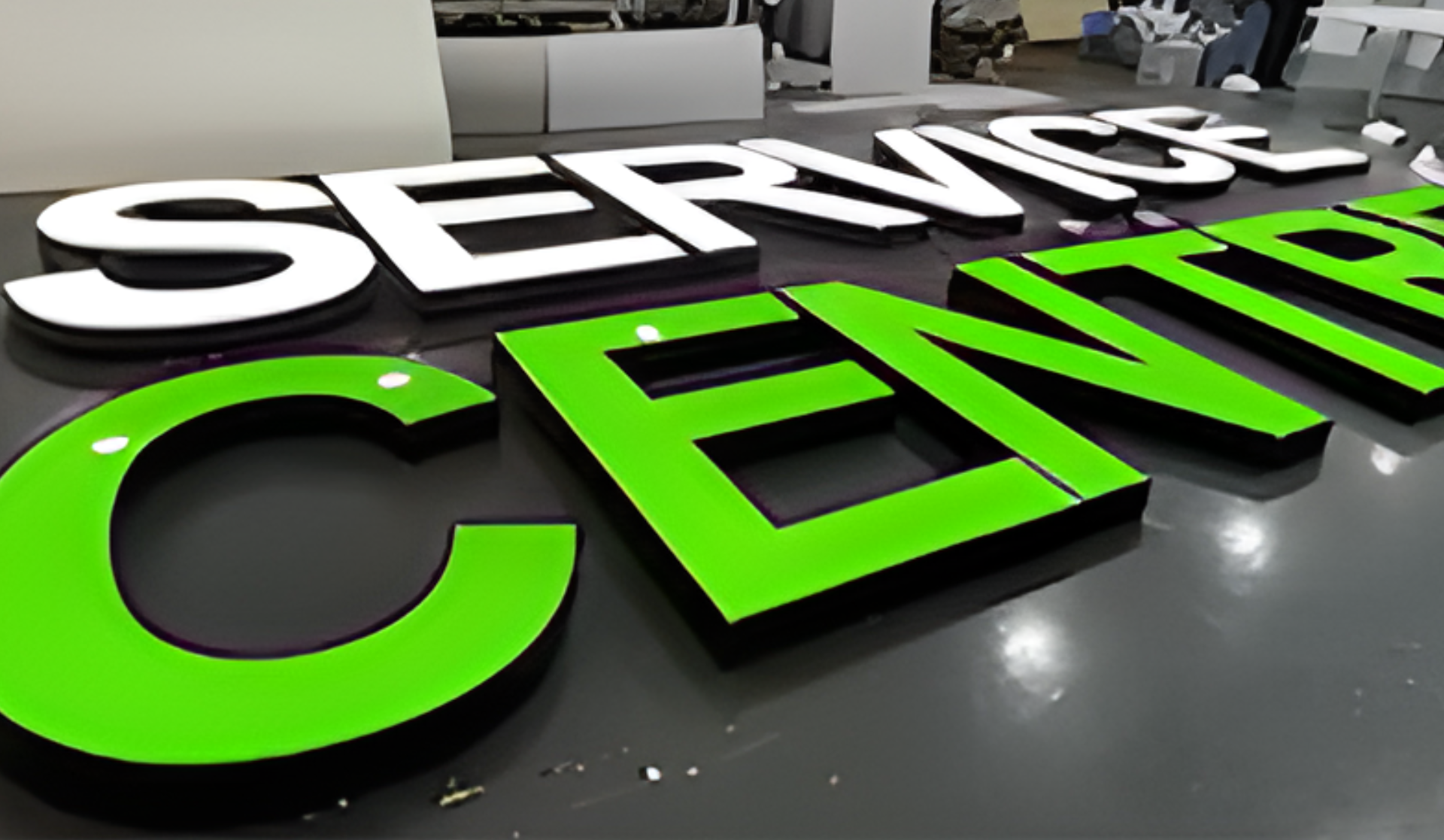 Große 3D-Buchstaben in Grün und Weiß auf dem Boden, Teil der Aufschrift „SERVICE CENTER“