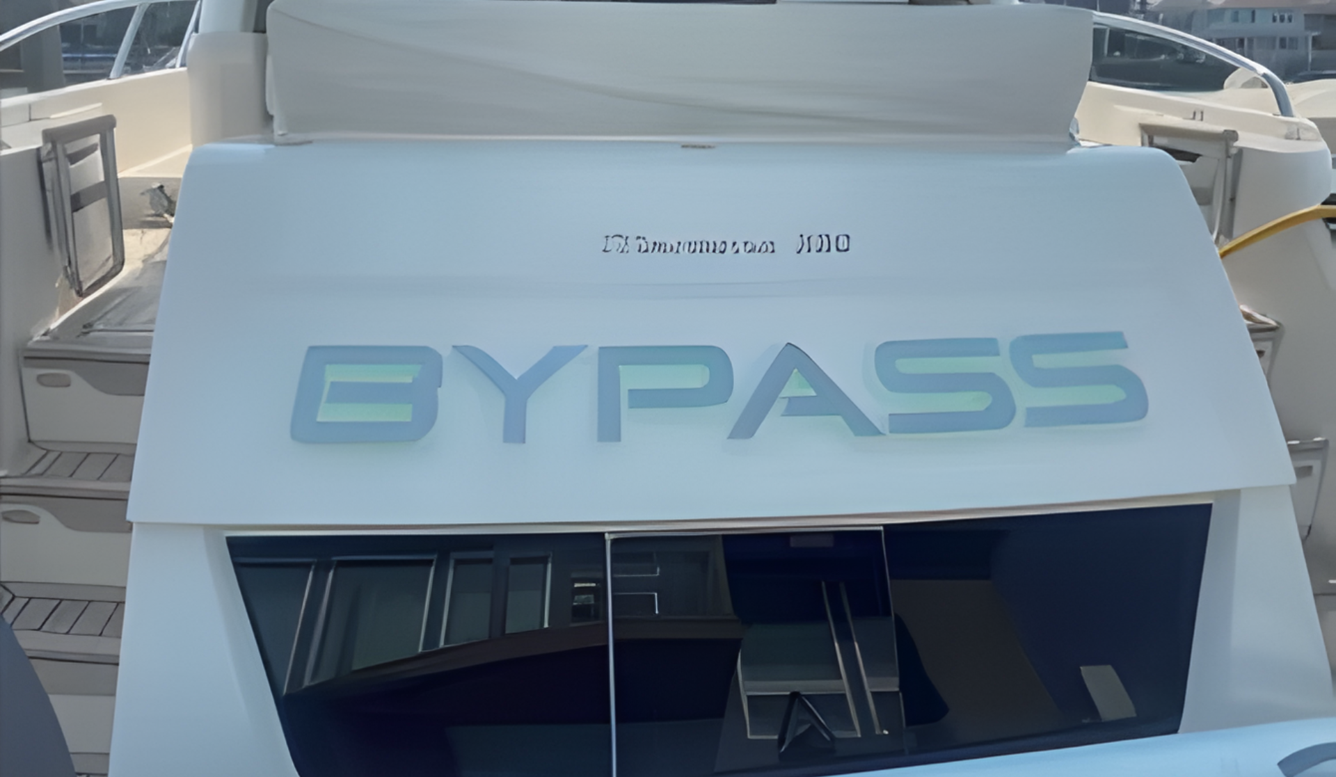 Heck eines weißen Luxusboots mit großem BYPASS-Schriftzug im Hafen