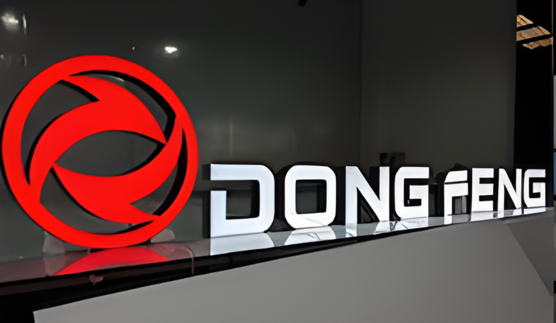 Leuchtendes rotes Logo neben dem Schriftzug DONGFENG auf dunklem Hintergrund