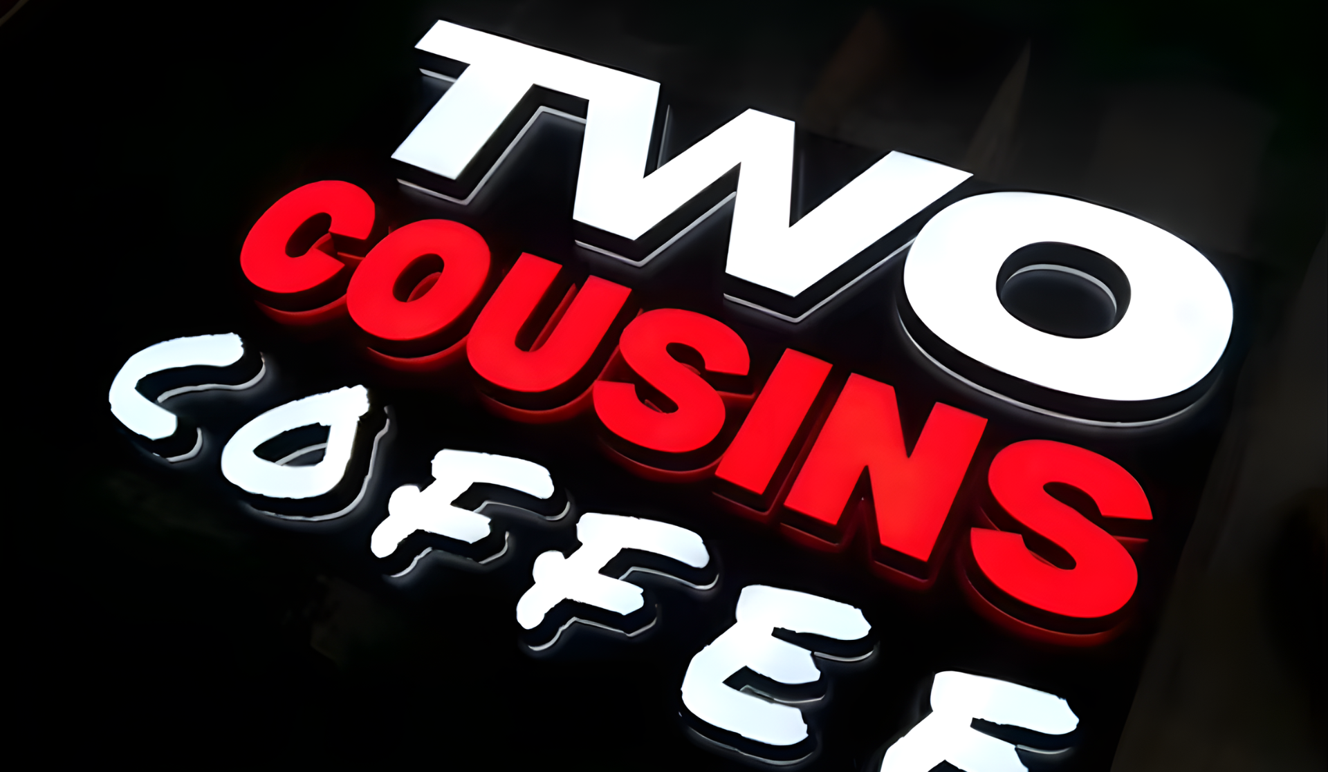 3D-Logo mit den Wörtern TWO COUSINS FREE in Weiß und Rot auf schwarzem Hintergrund