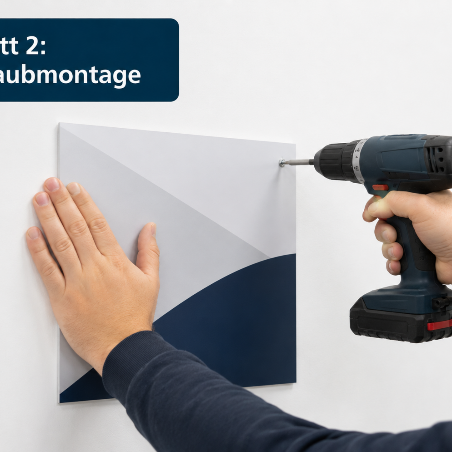 Mann befestigt mit Akkubohrer eine quadratische Metallplatte an der Wand, linke Hand hält die Platte zur Fixierung.