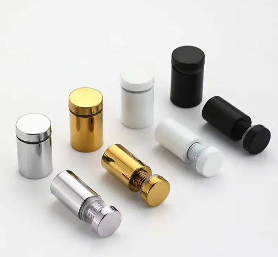 Mehrere kleine zylindrische Metallbehälter in Silber, Gold, Weiß und Schwarz auf hellem Hintergrund
