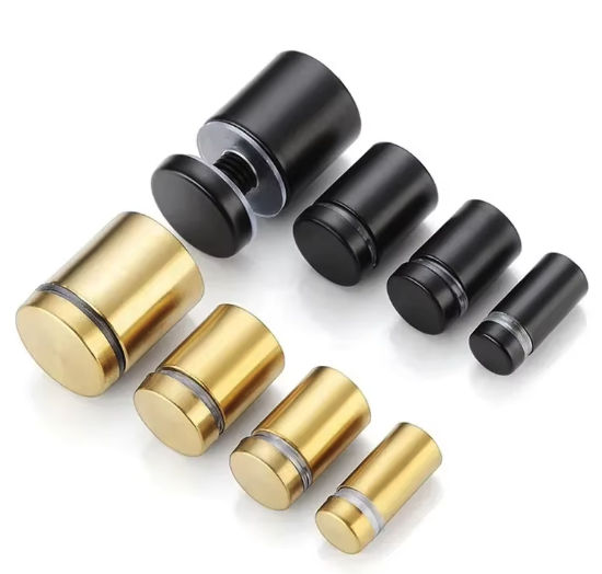 Mehrere zylindrische Metallstopper in Schwarz und Gold auf weißem Hintergrund