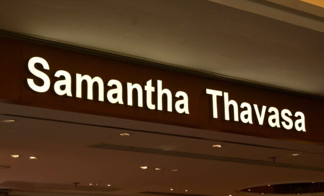 Leuchtende Schilderbuchstaben „Samantha Thavasa“ an der Fassade eines Geschäfts in einem Einkaufszentrum.