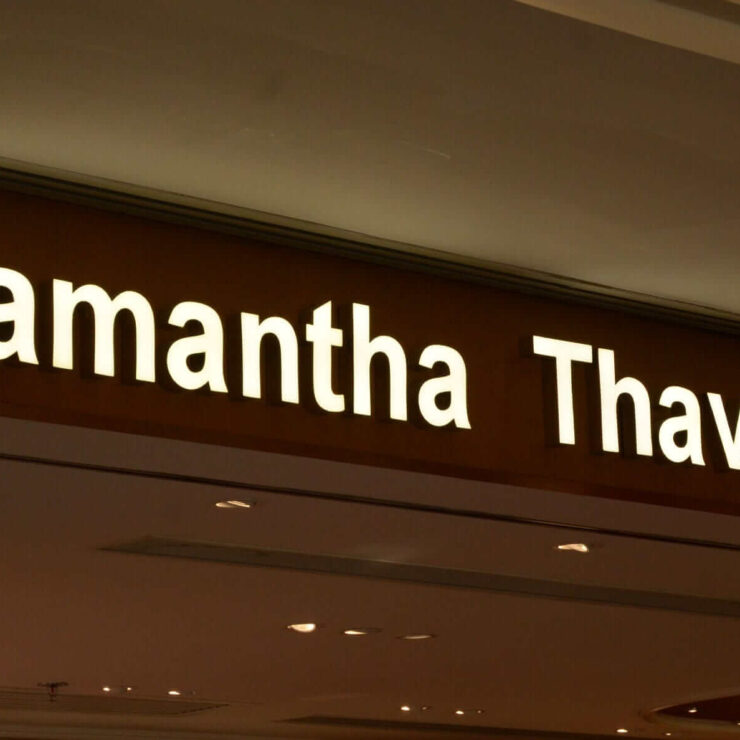 Leuchtende Schilderbuchstaben „Samantha Thavasa“ an der Fassade eines Geschäfts in einem Einkaufszentrum.